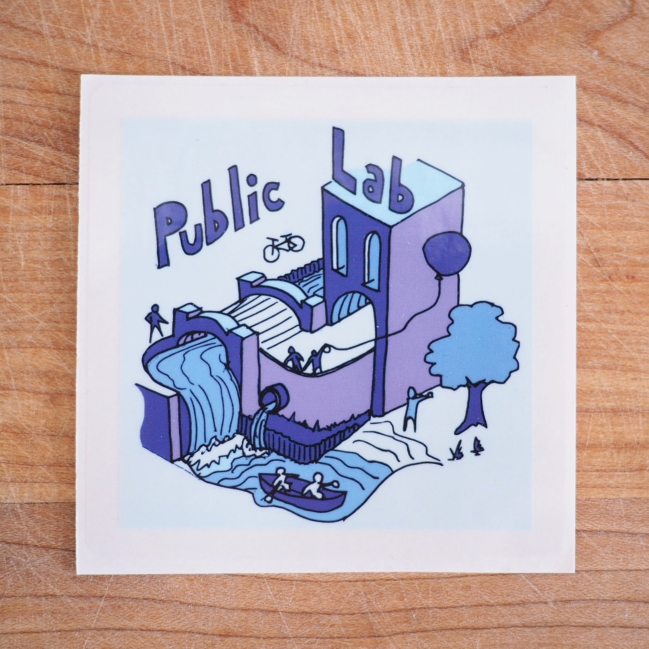 a blue sticker depicting a building and water coming out of a pipe into a river, canoers, and a balloon overhead with the words PUBLIC LAB